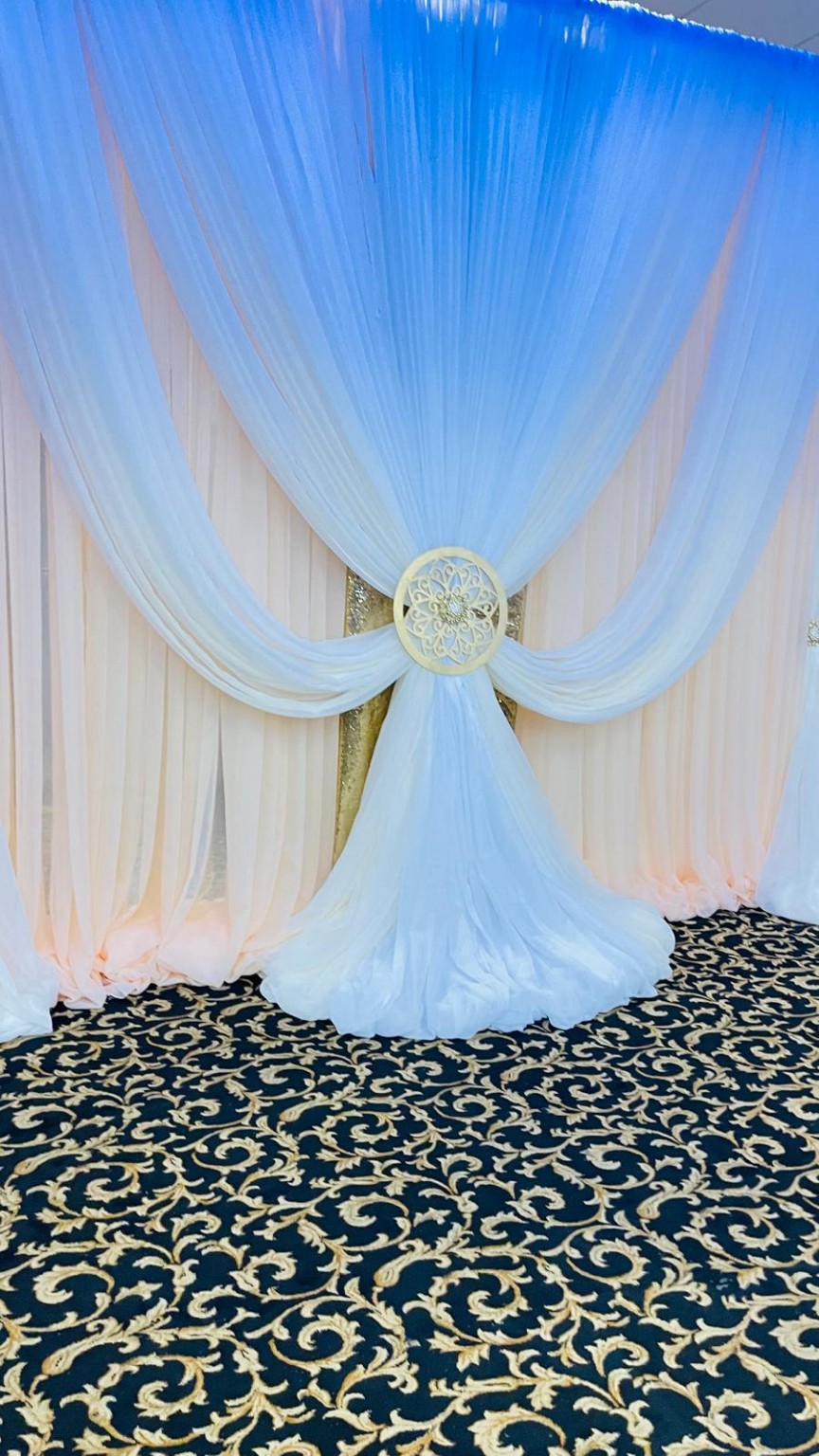 White gathered draping with a gold decorative centerpiece